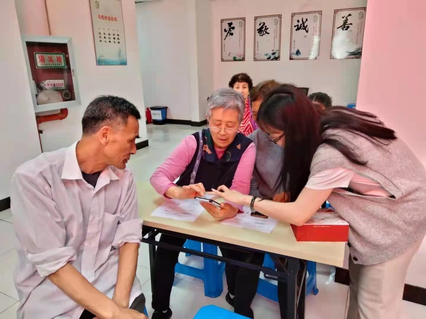 团队成员手把手教老年学员玩转智能手机
